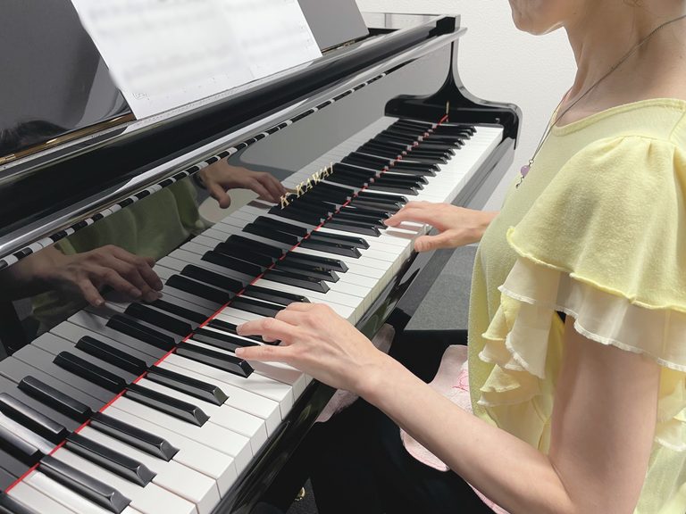 大人の女性がピアノを演奏している姿